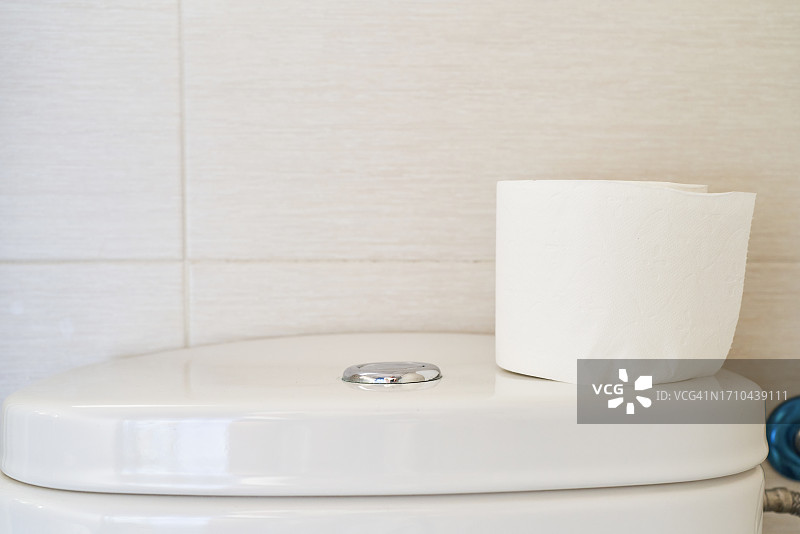 卫生间马桶盖和卫生纸，墙面瓷砖图片素材