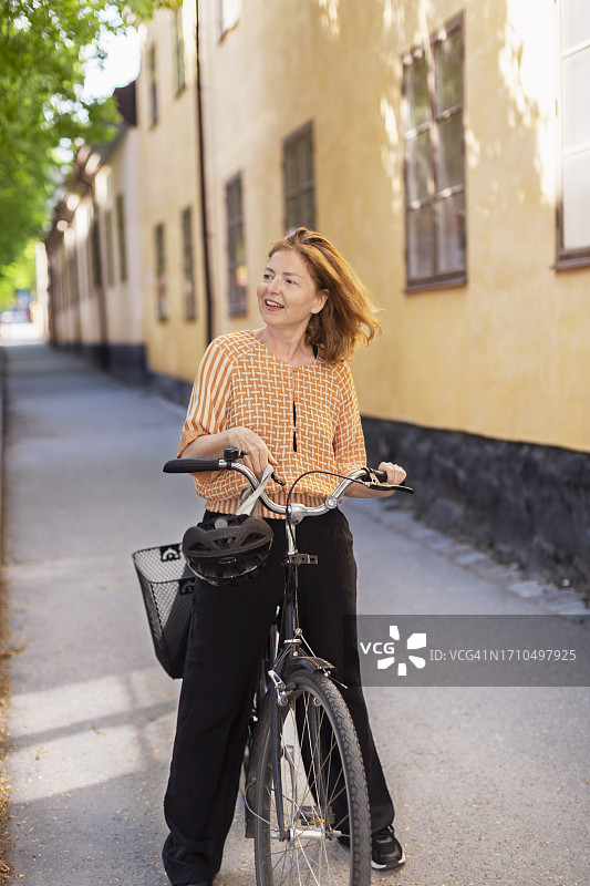 骑自行车微笑看向镜头的女人图片素材