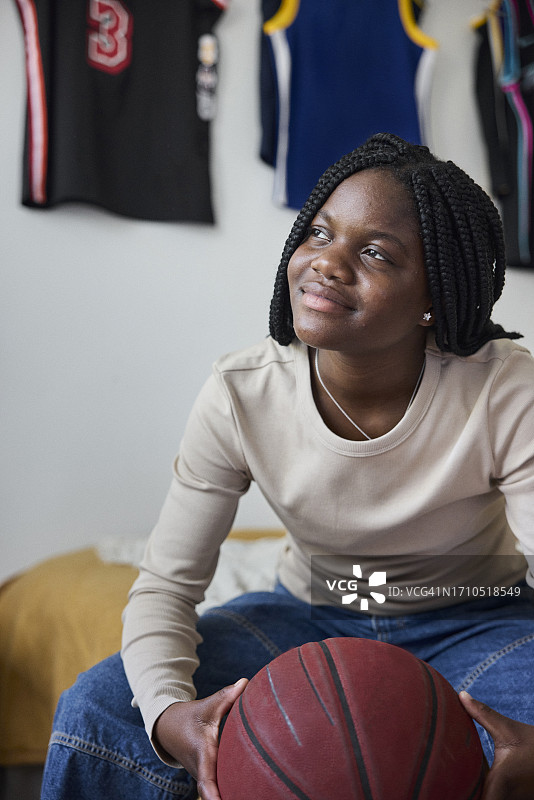 手持篮球并看向远方的微笑少女图片素材