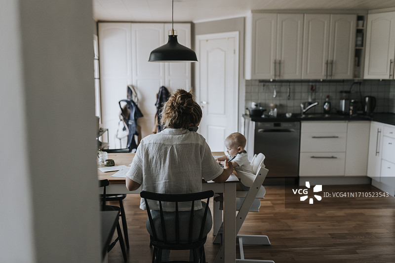 照顾孩子和在家办公的忙碌妈妈图片素材