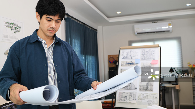 正在审查房屋设计蓝图的年轻建筑工程师图片素材