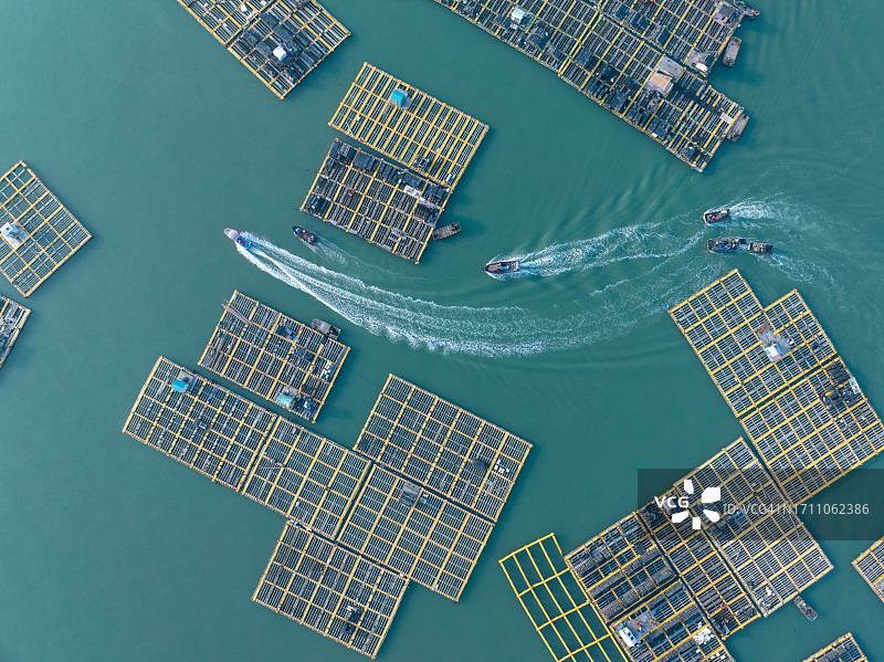 渔船在海上养殖场行驶，后面是波浪图片素材