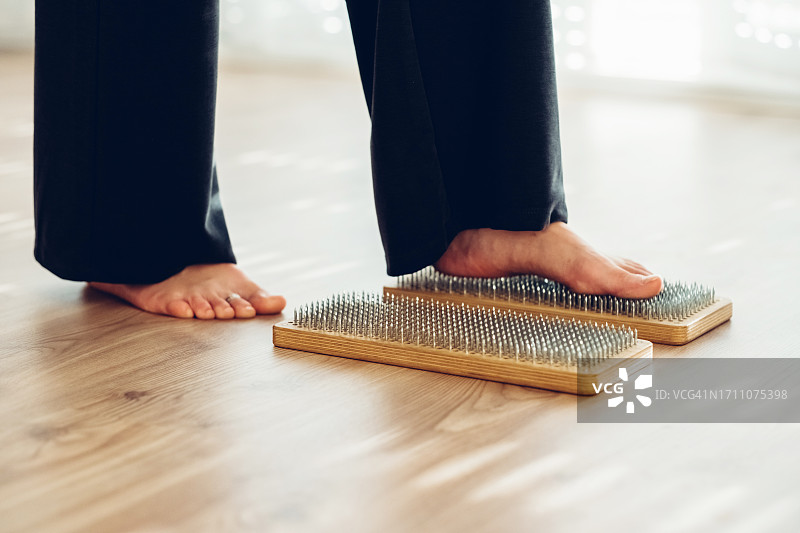 在家站在钉板上的女子（特写）图片素材