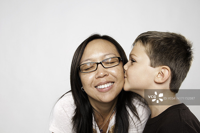 小男孩亲吻亚洲女性的脸颊图片素材