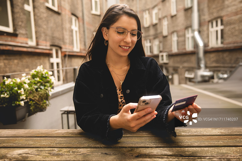 年轻女子使用智能手机在线购物图片素材