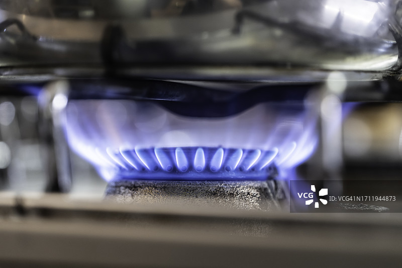 燃烧着蓝色火焰的现代厨房燃气灶图片素材