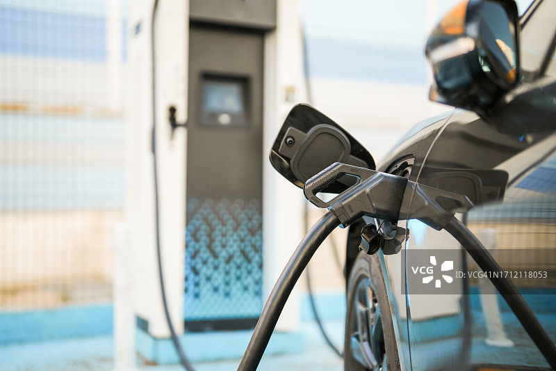 连接到充电站进行充电的电动汽车图片素材