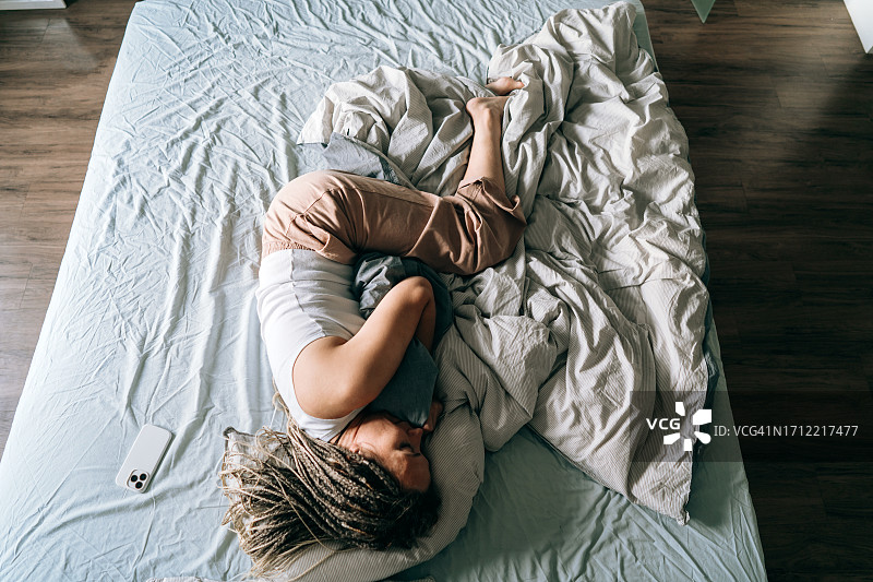 一位躺在床上玩手机的女士的肖像照图片素材