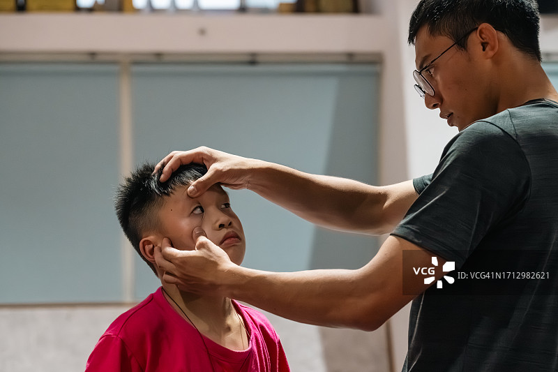 体育教练检查学生眼睛是否有受伤迹象图片素材