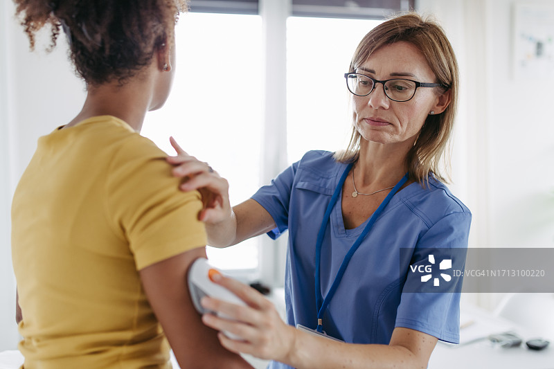 糖尿病专家为患者手臂安装连续血糖监测传感器图片素材