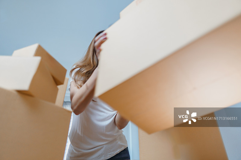 女商人检查订单，周围是包裹箱。拥有纸板箱的在线订单和配送业务的女老板。图片素材