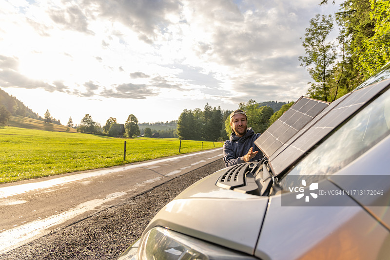男人在露营车上安装便携式太阳能电池板图片素材