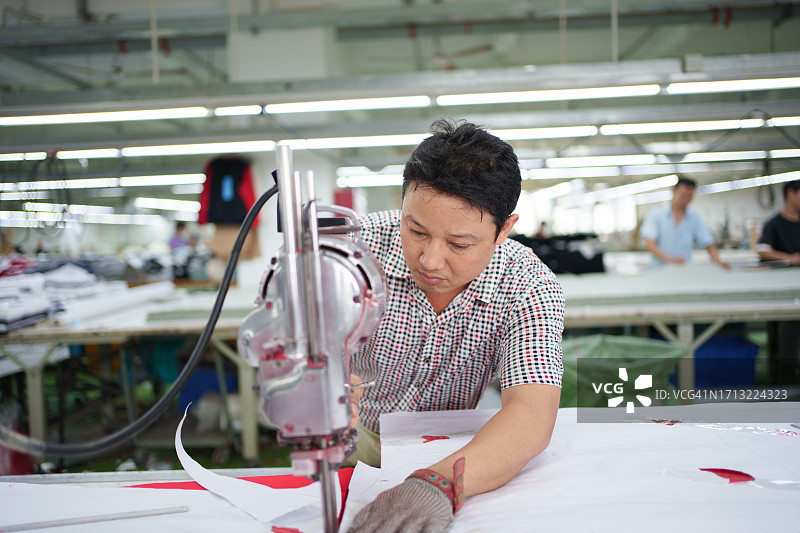 服装厂里的面料裁剪工人图片素材