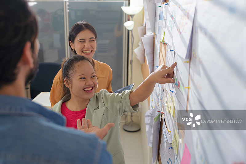 商务伙伴（包括有特殊需求的女性）在办公室讨论新项目图片素材