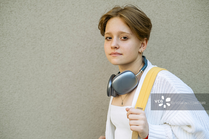 时尚少女拥抱学生生活，展示时尚耳机图片素材