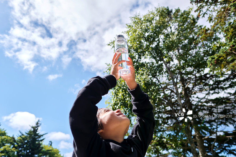 男孩手拿透明水瓶图片素材