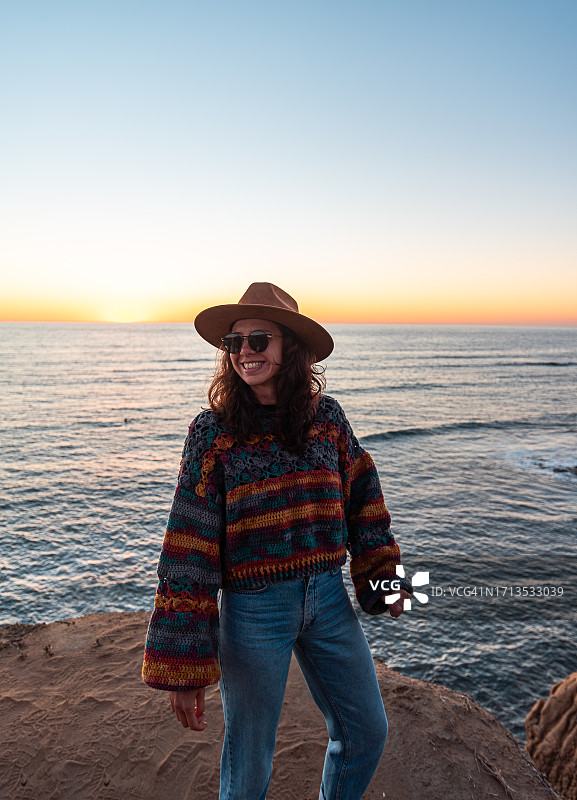 在加利福尼亚州圣地亚哥洛马岬日落悬崖的年轻女人和日落图片素材