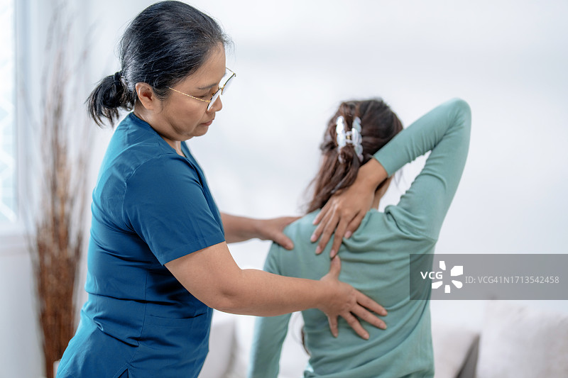 理疗师按摩患者的背部以治疗和减轻疼痛图片素材