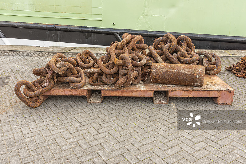 堆放在钢托盘上的巨大生锈钢链图片素材