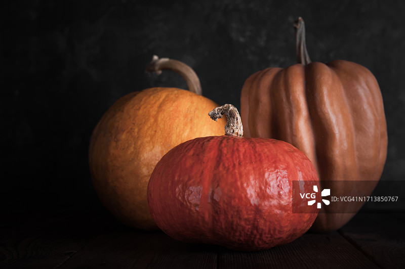 深色背景上的三个纹理南瓜特写图片素材