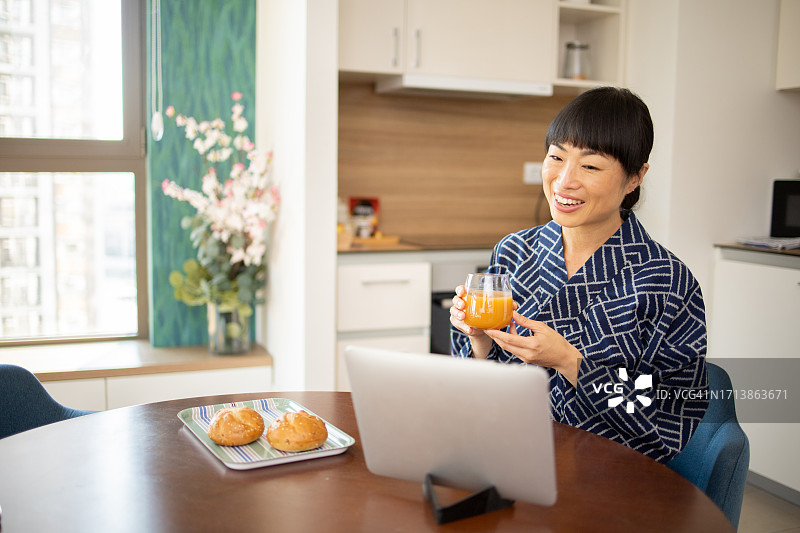 年轻女人在家中使用平板电脑图片素材