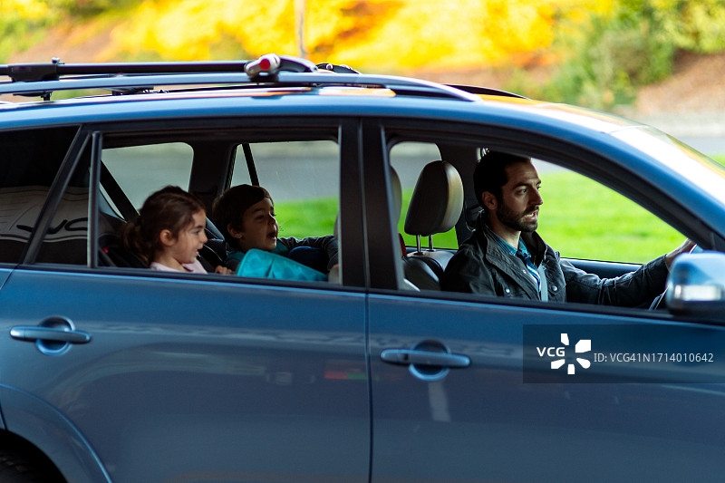 父亲开车送年幼的孩子上学图片素材