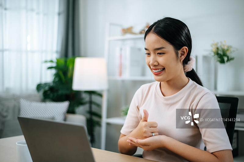 在家通过视频会议学习在线手语课程的亚洲女人图片素材
