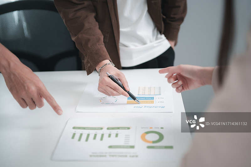 商人开会并指向带有数据的图表图片素材