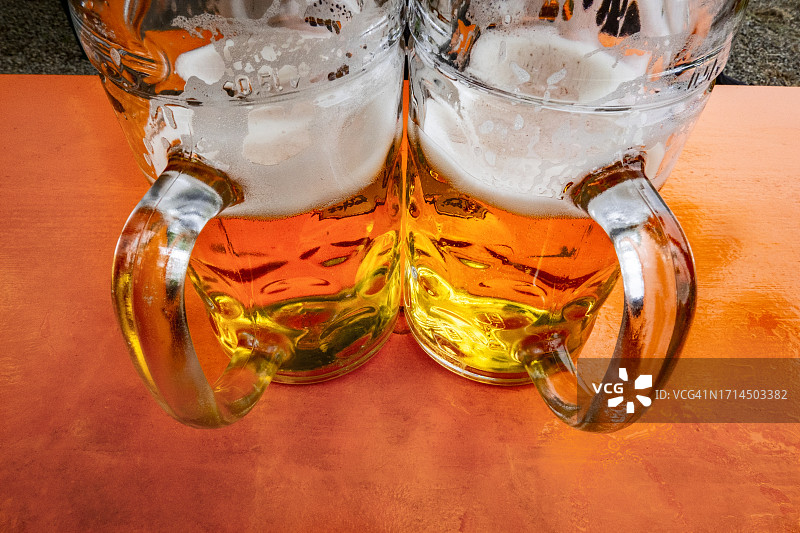 桌子上装有啤酒的两个大啤酒杯图片素材
