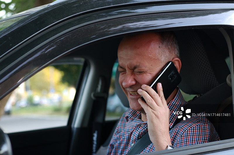 开车时使用手机的中年男人图片素材