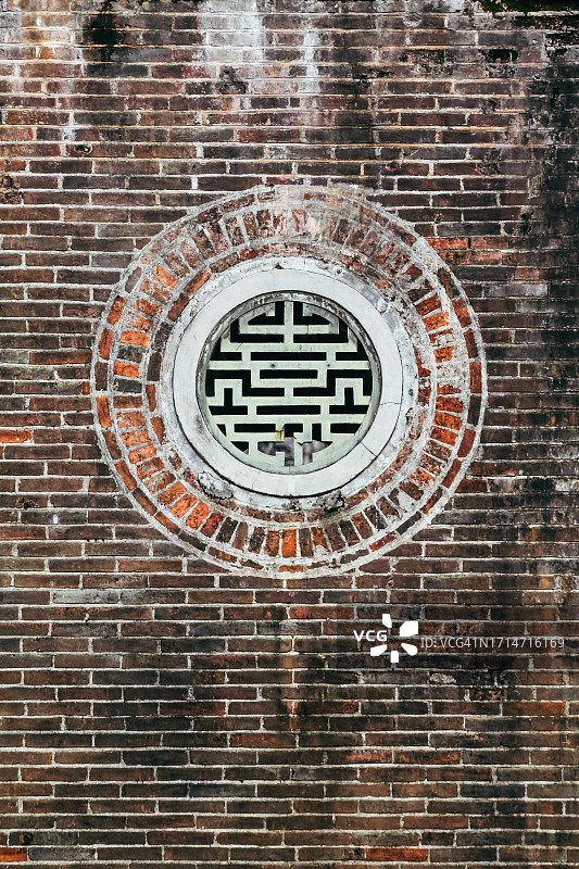 砖墙上带有中国长寿符号的圆形窗户图片素材