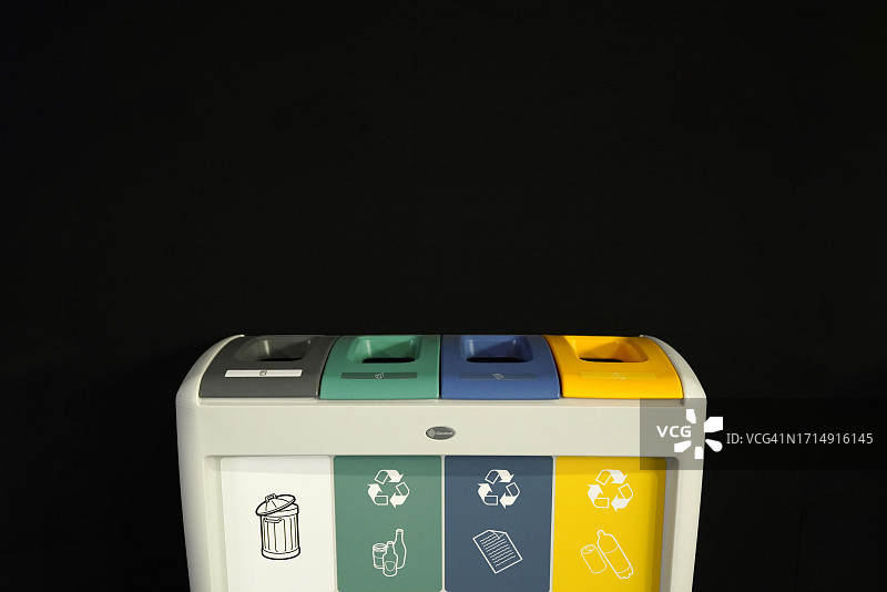 黑色背景下的彩色回收垃圾箱图片素材