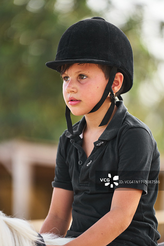 专心致志的男孩户外骑马图片素材