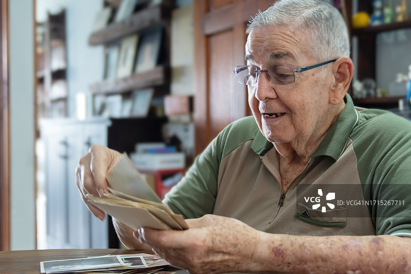 白发老人欣赏老式家庭照片图片素材