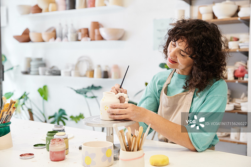 女人在陶艺作坊里绘制手工陶瓷图片素材