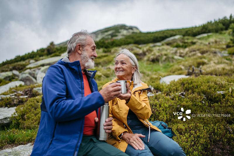 年长游客在秋季登山途中休息图片素材