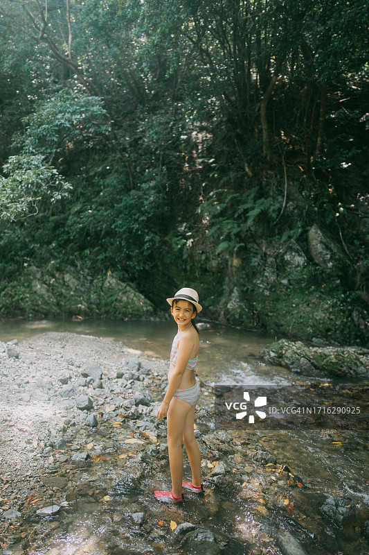 在森林溪流中行走的年轻女孩图片素材