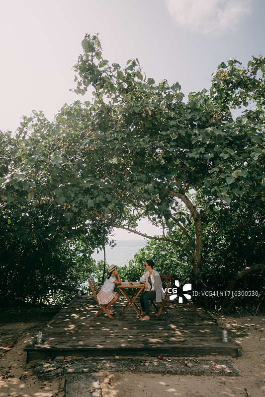 母亲和年幼的女儿在海边玩得很开心图片素材