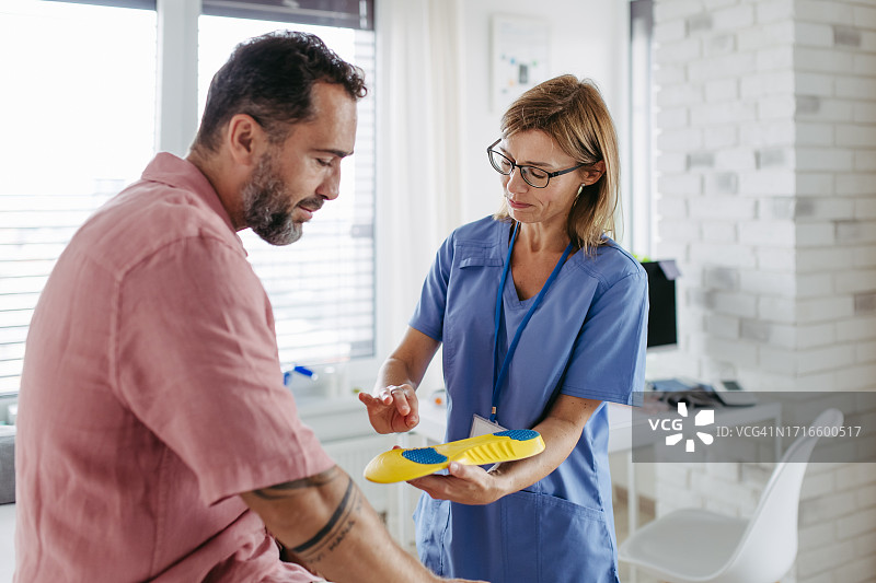 糖尿病专家向患者展示糖尿病鞋垫图片素材