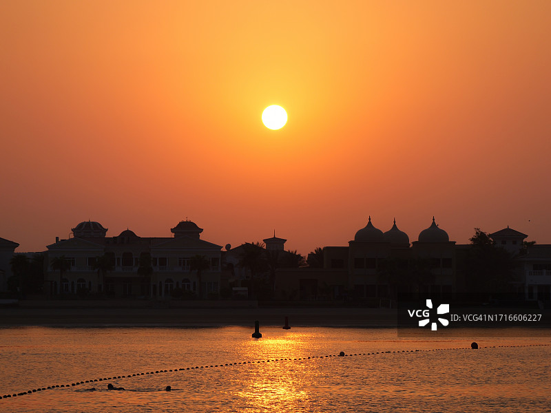 阿联酋迪拜 - 棕榈岛和海湾的日落景观，阴影中的别墅图片素材