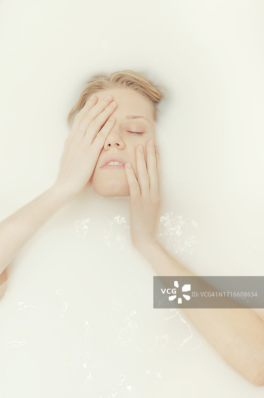 在牛奶浴中的年轻女性肖像图片素材