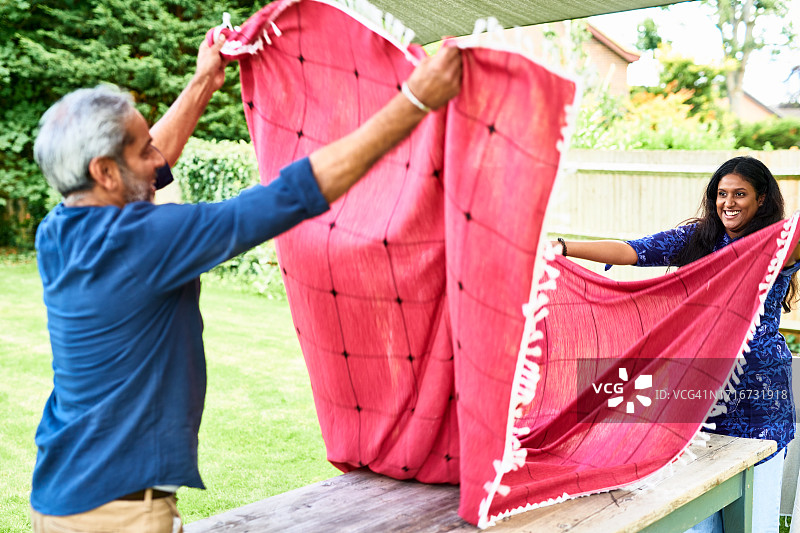 印度老年夫妇在户外桌子上铺红色桌布图片素材