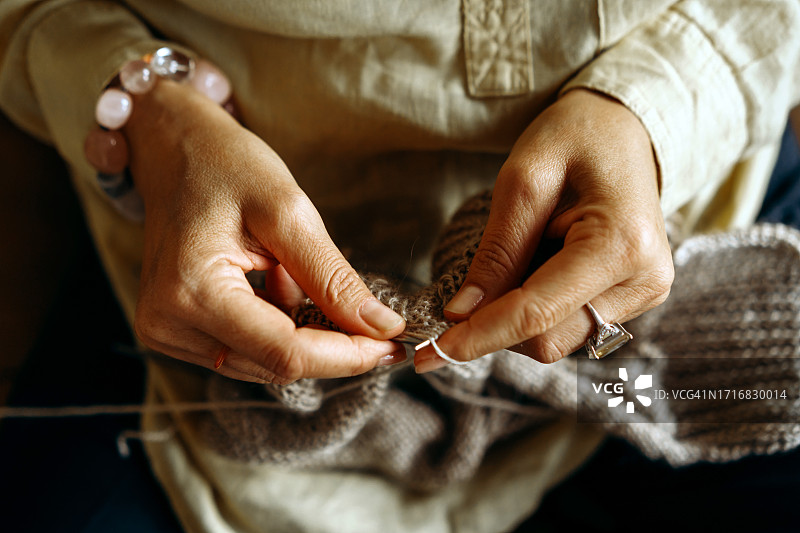 女人用毛线编织衣服的手部特写图片素材