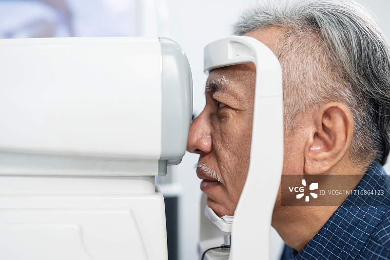 降低老年患者视力丧失风险，提高视觉障碍的可见性：男性在眼科接受眼科医生检查的侧视图图片素材