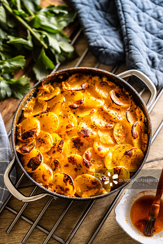 陶瓷罐中烤制的酥脆土豆。在东欧被称为法式土豆。土豆、熏香肠、鸡蛋和奶油。图片素材