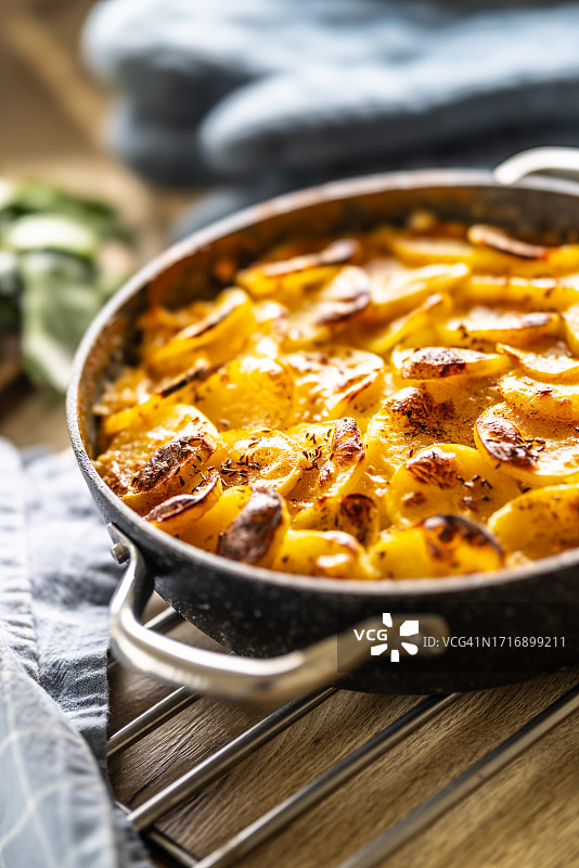 陶瓷罐中烤制的酥脆土豆。在东欧被称为法式土豆。土豆、熏香肠、鸡蛋和奶油。图片素材