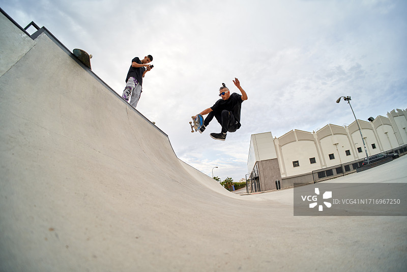 两名西班牙裔朋友在滑板公园滑冰图片素材