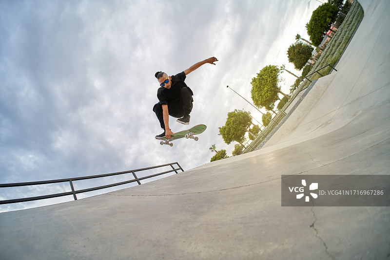 在滑板公园滑冰的年轻拉美裔男子图片素材