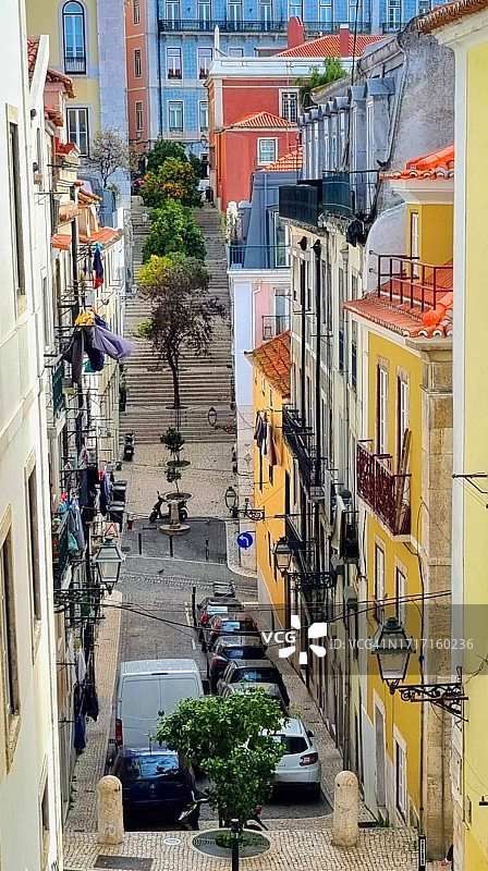 葡萄牙里斯本老城区里有橙树和楼梯的彩色街道图片素材
