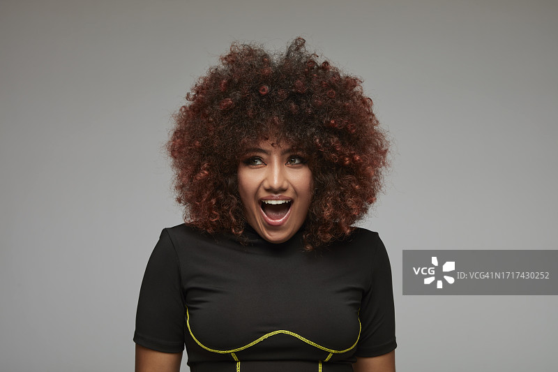 兴奋的卷发混血女人图片素材